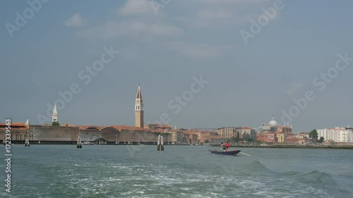 View from Venice Italy from a ferry passing by rowing sporters photo