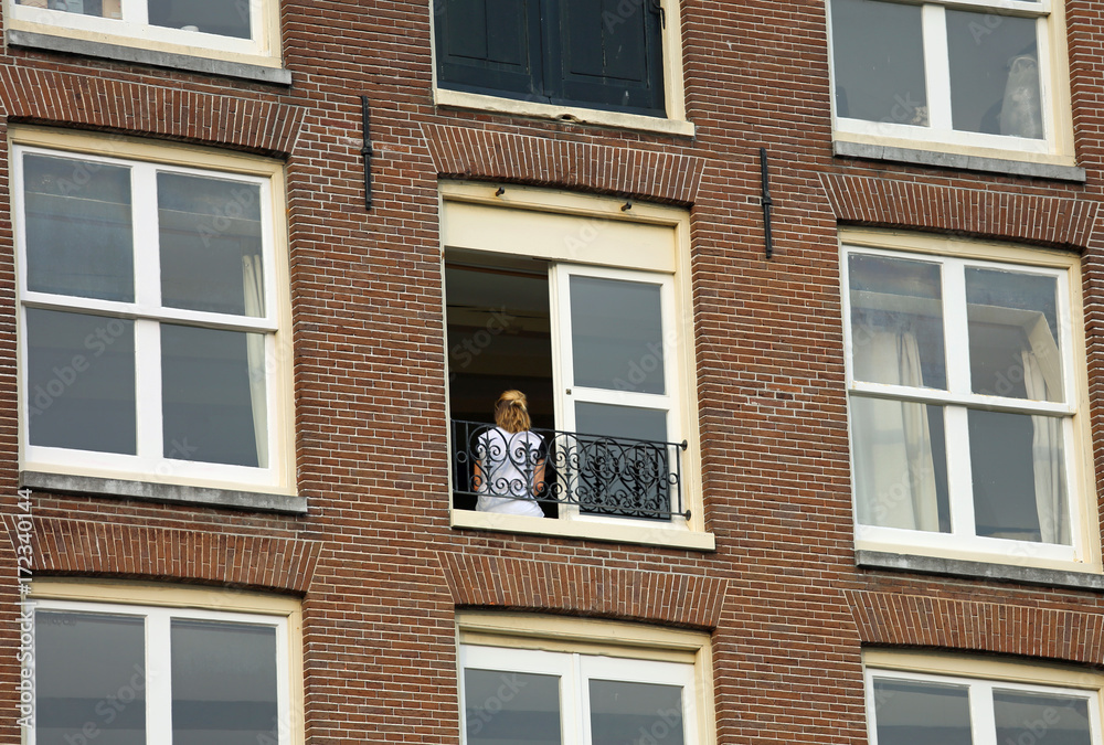 blonde girl at the apartment building window blonde girl at the apartment building window