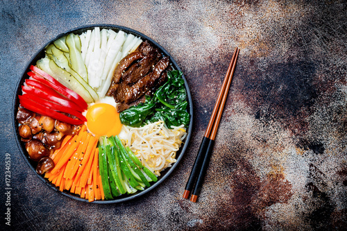 Bibimbap, traditional Korean dish, rice with vegetables and beef. Top view, overhead, flat lay, copy space