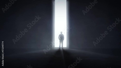 Man standing in the front of an opening wall with light coming trough