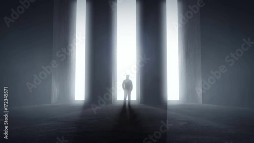 Man standing at opening glowing light tunnels in front of a high concrete wall, decision concept