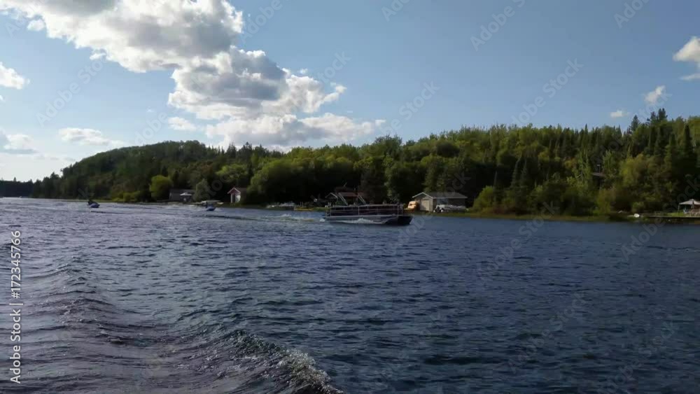 Clip taken from a pontoon boat moving swiftly along the river. 2 jet skis and another pontoon boat are gaining on the camera boat and begin to overtake. Clip taken from a pontoon boat moving swiftly along the river. 2 jet skis and another pontoon boat are gaining on the camera boat and begin to overtake.