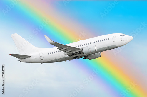 Climbing airplane against a rainbow in the sky