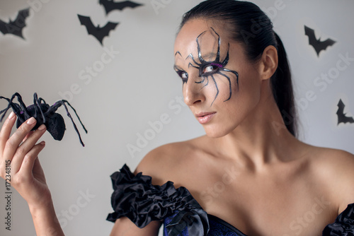 Beautifull witch holding spider. Concept Halloween