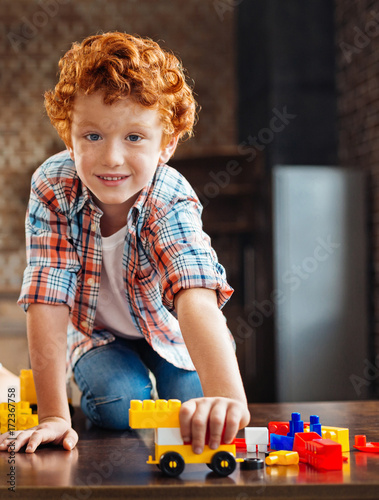 Beautiful blue eyed boy looking into camera while playing