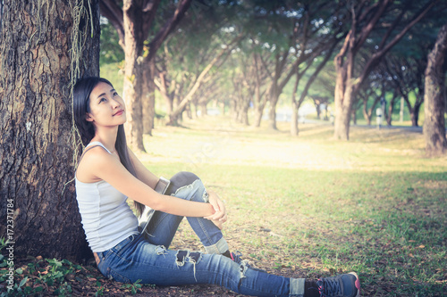 The girl is relaxing under the tree.