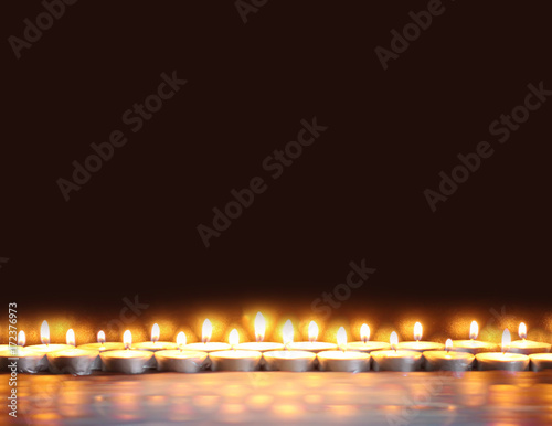 Burning candles on dark background.