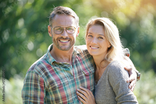 Portrait of mature couple enjoying sunny day in nature photo