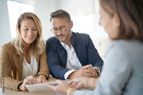 Mature couple meeting real-estate agent in office photo