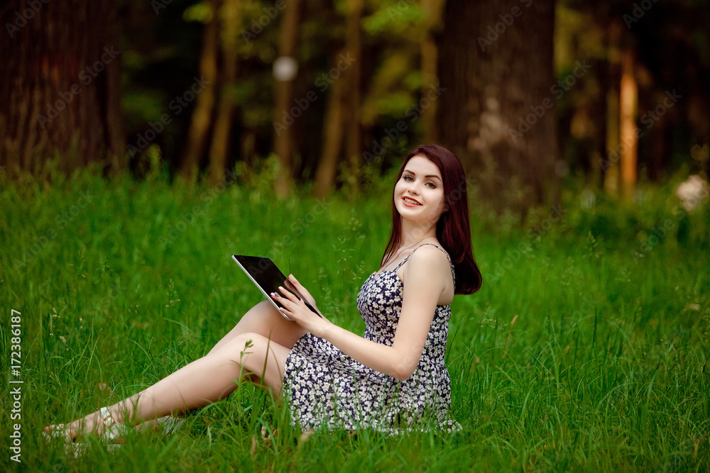 Brunette woman talking in a video call on line on nature Brunette woman talking in a video call on line on nature