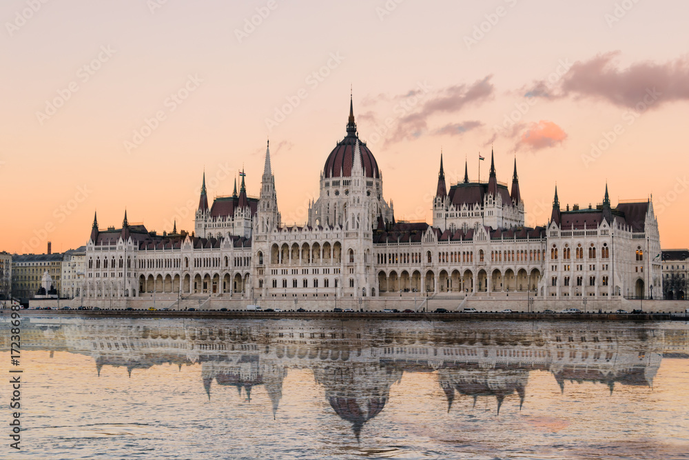 Naklejka premium Spiegelung des Parlaments in Budapest in der Donau während eines Sonnenuntergangs