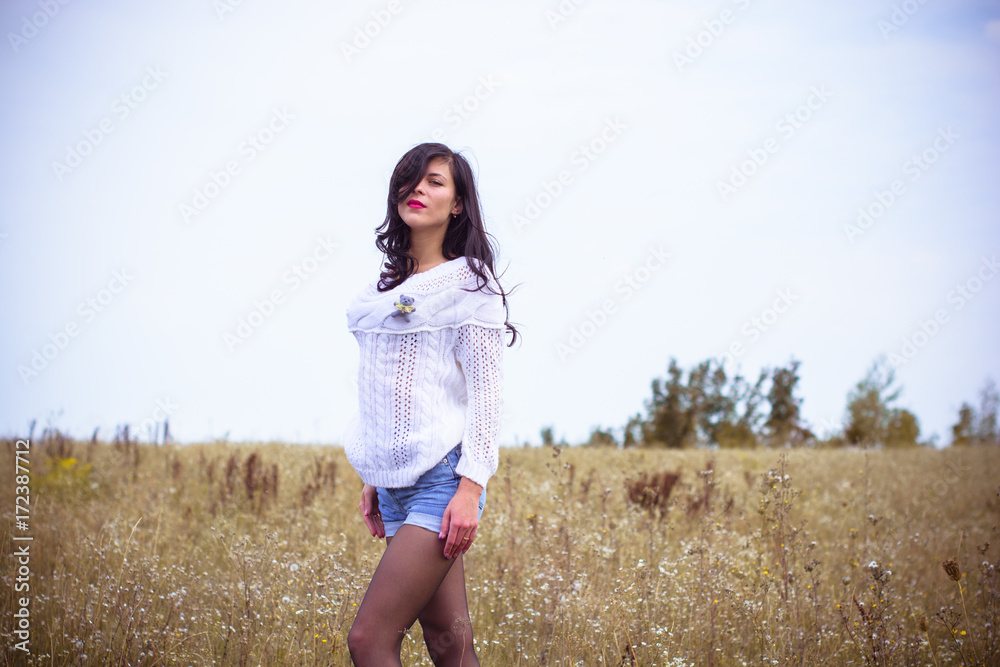 Pretty woman in a white knitted sweater, shorts and boots, stylishly dressed in a field in the fall. A nice and sexy look for beautiful walks and dates at autumn Pretty woman in a white knitted sweater, shorts and boots, stylishly dressed in a field in the fall. A nice and sexy look for beautiful walks and dates at autumn