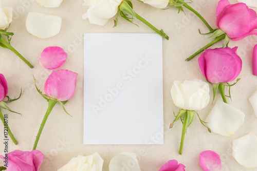 Fototapeta Naklejka Na Ścianę i Meble -  Blank white card decorated with white and pink roses on white muslin fabric with copy space