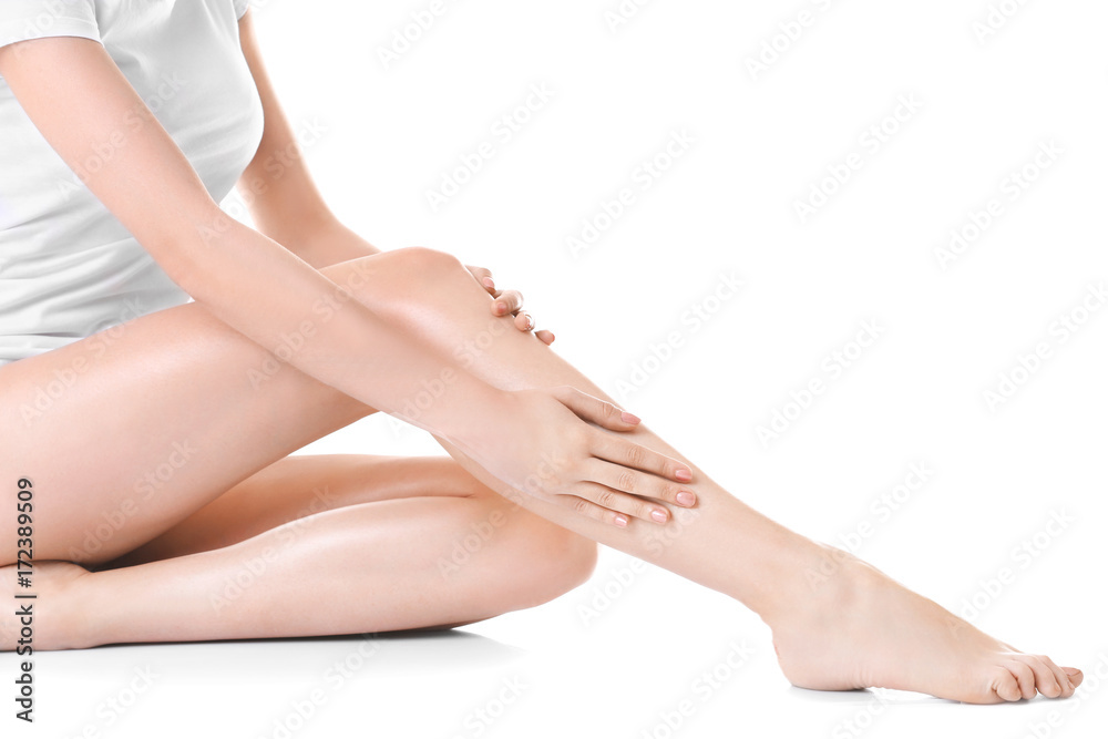 Young woman touching her leg on white background Young woman touching her leg on white background
