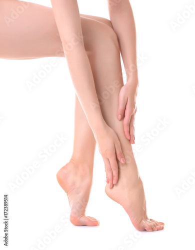 Young woman touching her leg on white background © Africa Studio