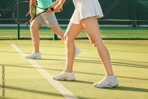 Young couple playing tennis on court © Africa Studio