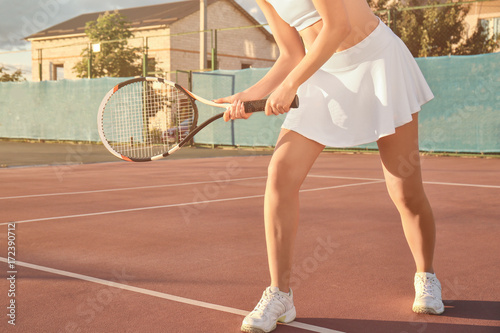 Young woman playing tennis on court © Africa Studio
