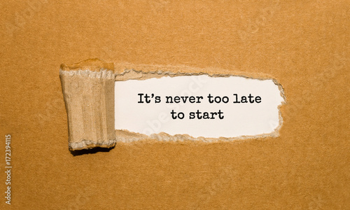 The text Its never too late to start appearing behind torn brown paper