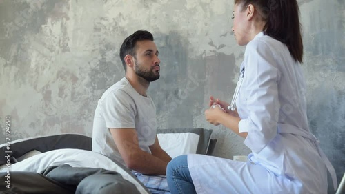 Medical worker examining patient throat with tongue depressor