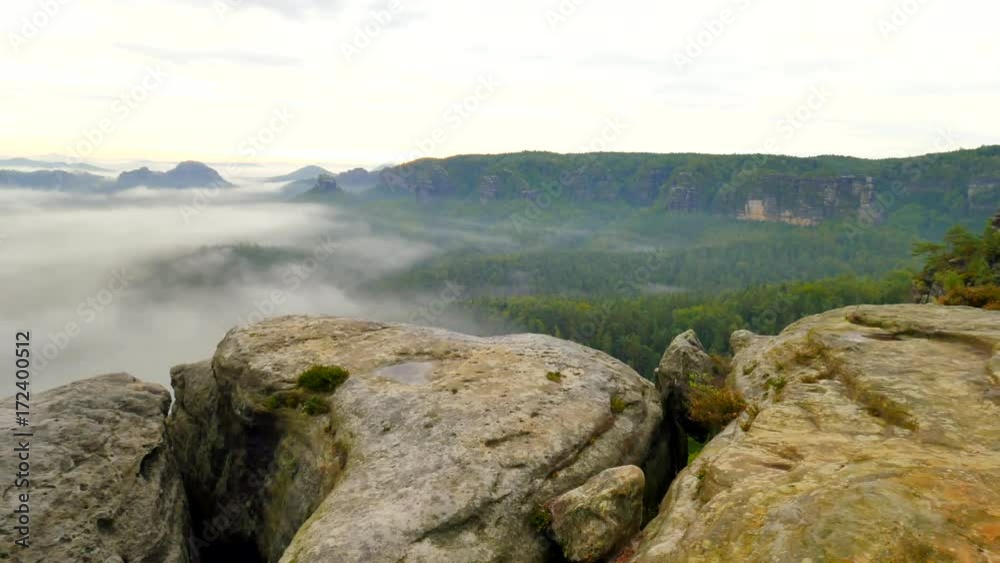 Spring misty morning in forest landscape. View around. Majestic peaks cut lighting mist. Deep valley is full of colorful fog and rocky hills are sticking up to Sun. Spring misty morning in forest landscape. View around. Majestic peaks cut lighting mist. Deep valley is full of colorful fog and rocky hills are sticking up to Sun.