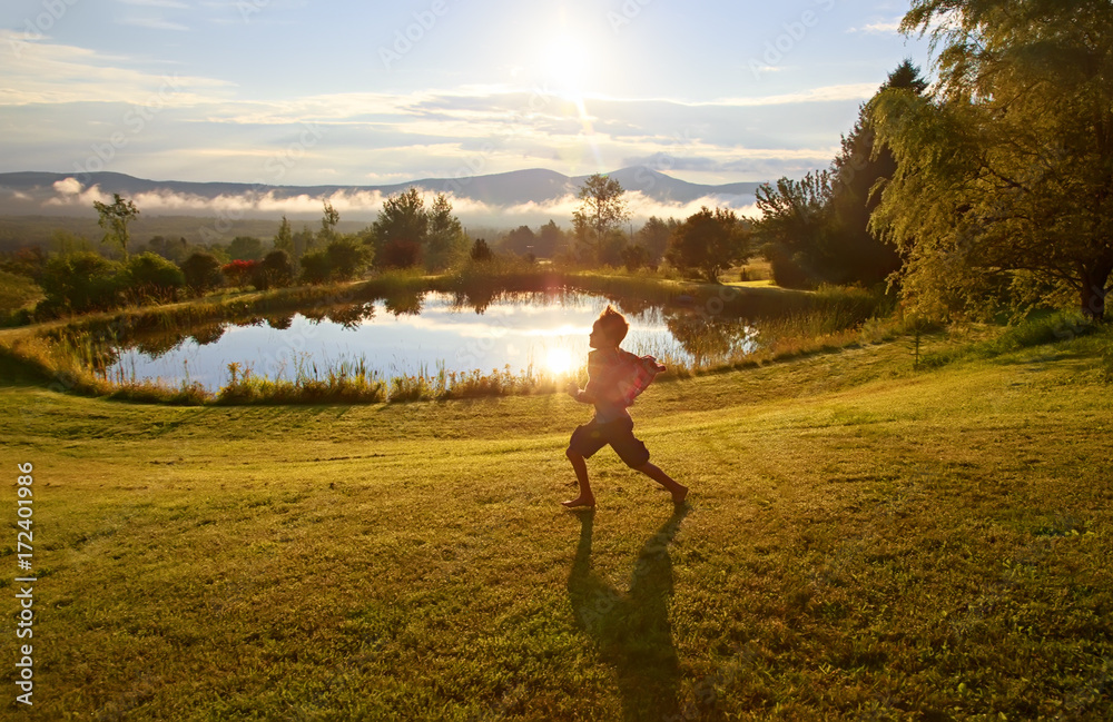 boy runs on the morning dew. the child rejoices at the coming of a new day. Copy space for your text 