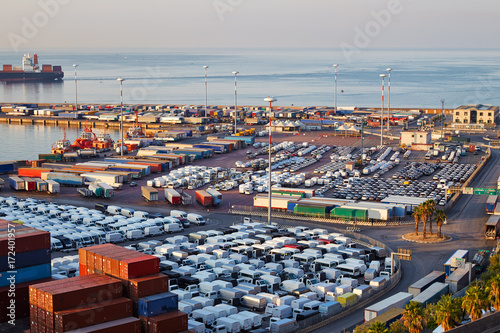 Port terminal with containers  new cars and wagons in the early morning