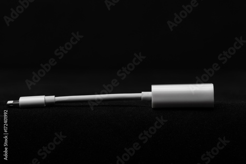 White adapter for mobile phone on black background