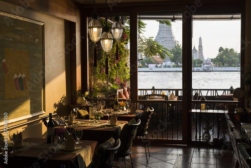 Luxury restaurant overlooking Wat Arun at sunset time, Bangkok, Thailand photo