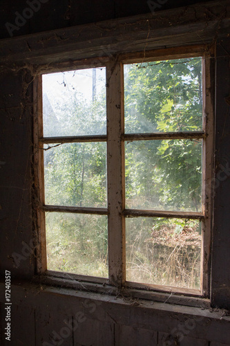 Window of an abandoned house, from the inside, sunlight seen outside