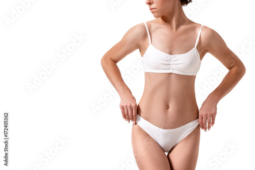 Slim tanned woman's body. Isolated over white background.