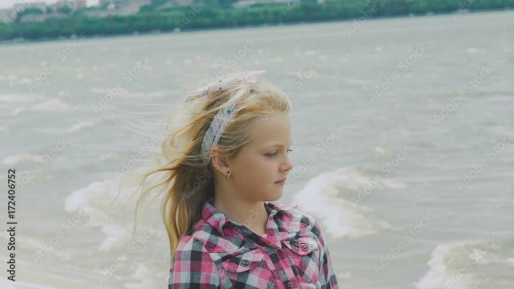 Glamorous and stylish blonde posing and looking at camera on the coast. Slowly Glamorous and stylish blonde posing and looking at camera on the coast. Slowly