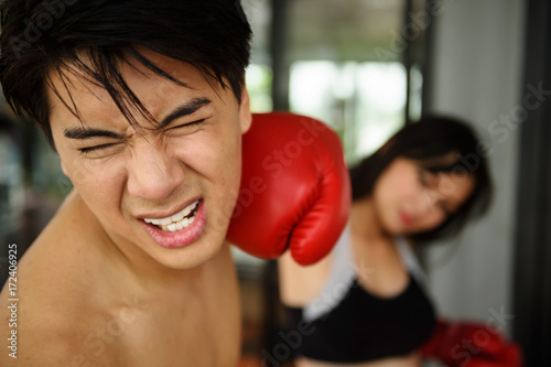 man face punched by  girl right hand boxing glove © Blanscape
