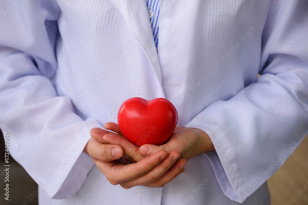 doctor hands holding red toy heart doctor hands holding red toy heart