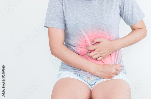 Young woman feeling unwell with a stomach ache on white background.