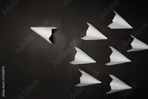  concept 3D paper airplane on opposite direction with isolated black background