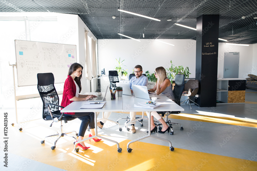 Three business people in the office talking together. Three business people in the office talking together.