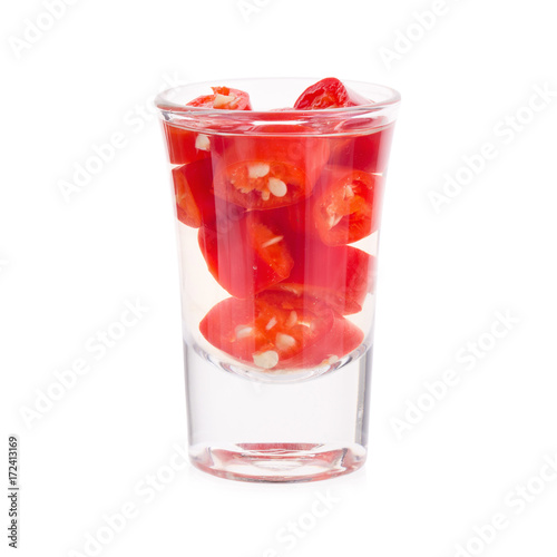 Slices of preserved red hot pepper in glass isolated on a white background