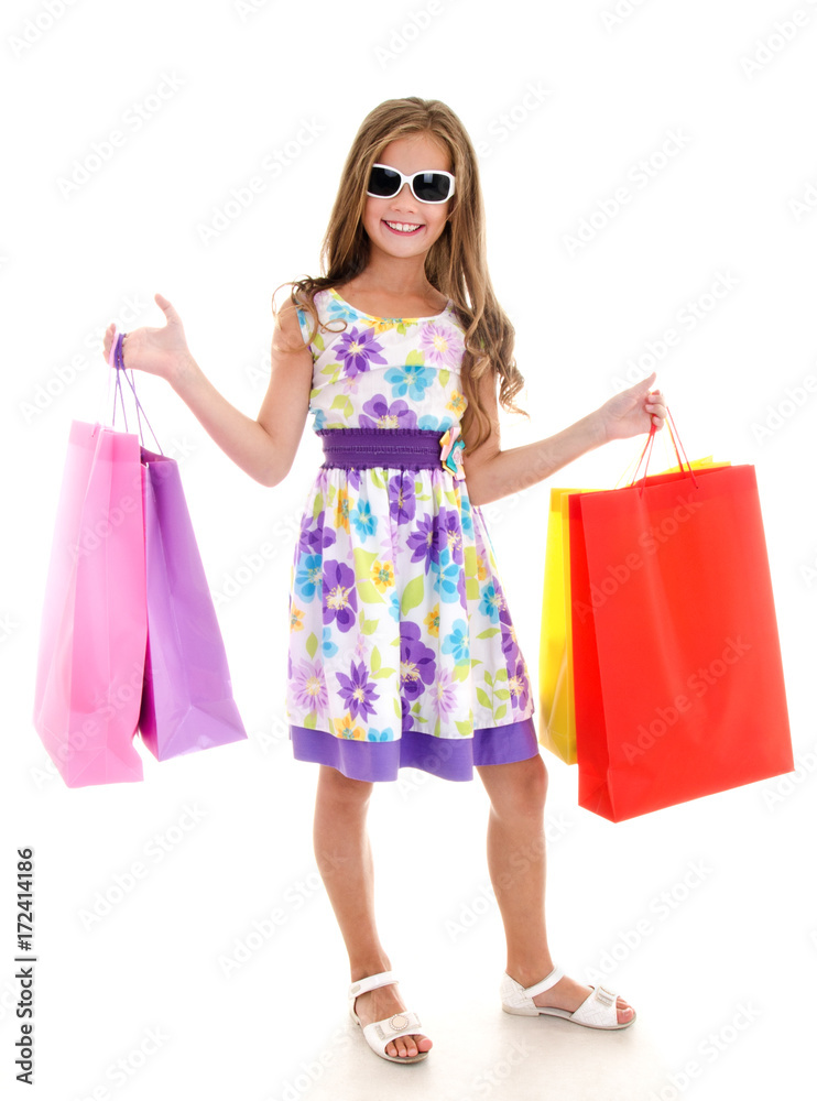 Adorable little girl child in sunglasses holding shopping colorful paper bags Adorable little girl child in sunglasses holding shopping colorful paper bags