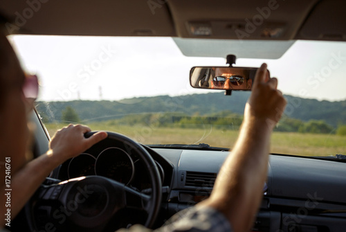 Men checking the rearview mirror before traveling.