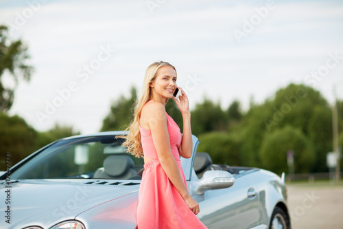 woman calling on smartphone at convertible car © Syda Productions