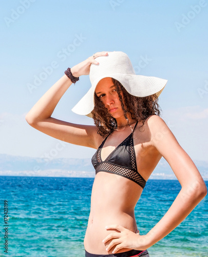 Young girl with hat at the sea