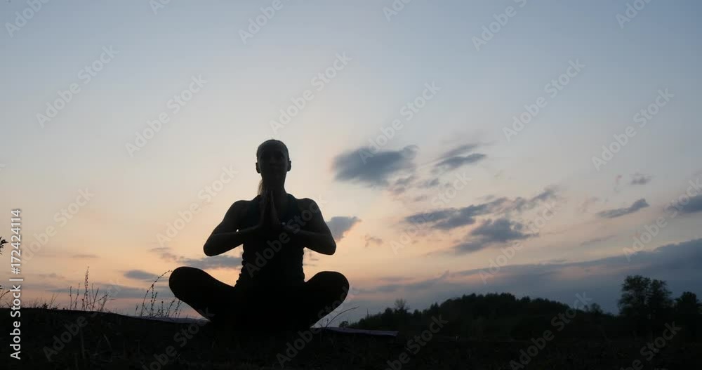 Silhouette young woman practicing yoga at sunset 4k Silhouette young woman practicing yoga at sunset 4k