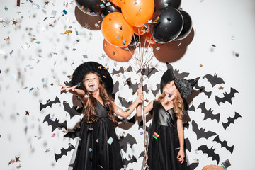 Couple of two happy little girls dressed in halloween costumes