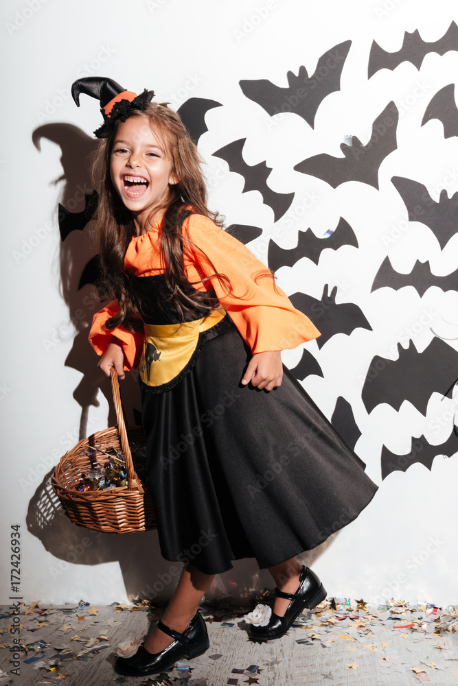 Happy little girl dressed in halloween costume posing