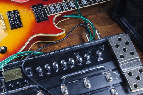 Guitar and stompbox laying there on the stage photo