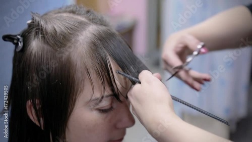 Hairdresser makes hairstyle for young girl