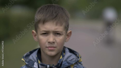 portrait of a serious boy with a tence glance looking at the camera, close-up heavy face photo