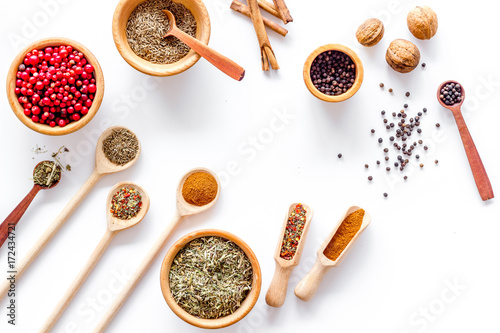 Colorful dry herbs and spices for cooking food white kitchen table background top view pattern