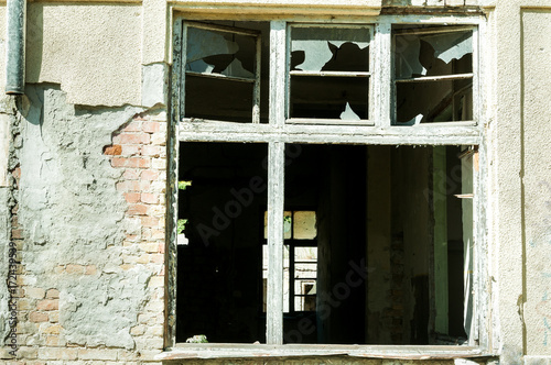 Demolished window of abandoned ruined house destroyed by grenade explosion in the war zone