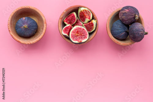 Fresh blue figs in bowls on pink background top view copyspace